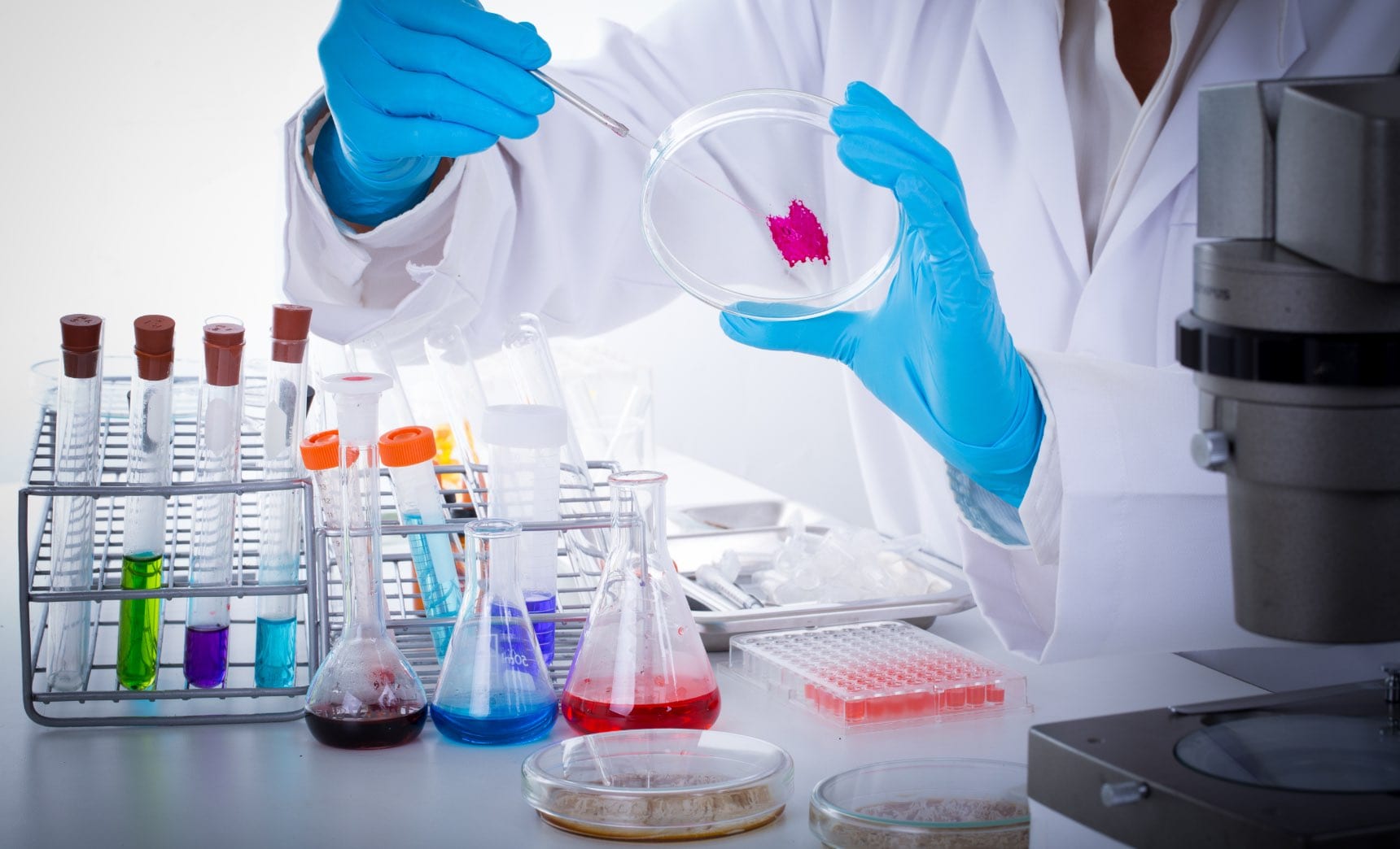 Hands holding a urine sample tube beside a plain home collection kit on a bathroom counter, for a page on toxin testing